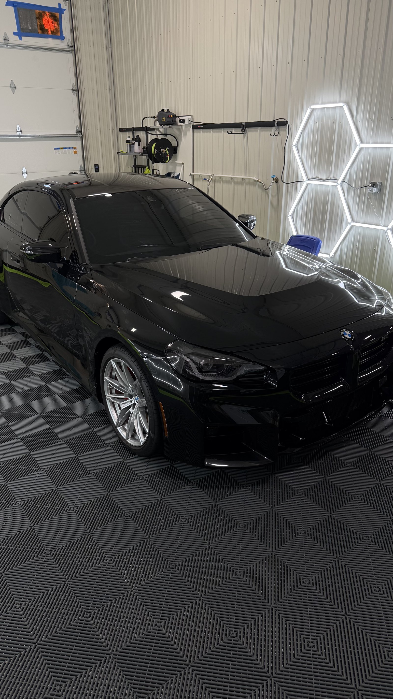Glossy black BMW M4 with ceramic coated paint in a Kansas City detailing showroom