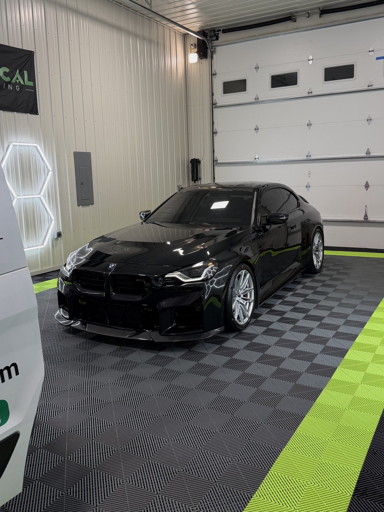 Black BMW M4 with corrected paint finish in a Kansas City detail shop